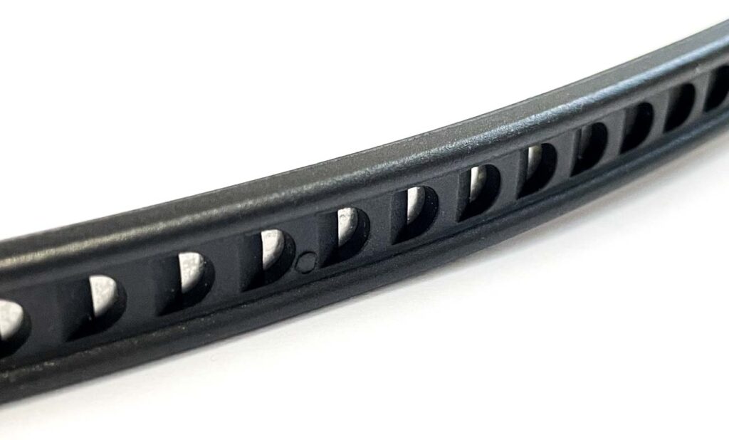 Detailbild des Kabelbinder-Schlosses. Deutlich zu sehen: der verstärkte Stahlkern im Innern. Detailbild des Kabelbinder-Schlosses mit verstärktem Stahlkern
