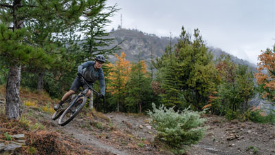 Radfahrer fährt im Wald auf einem Cube Stereo Fully Mountainbike.